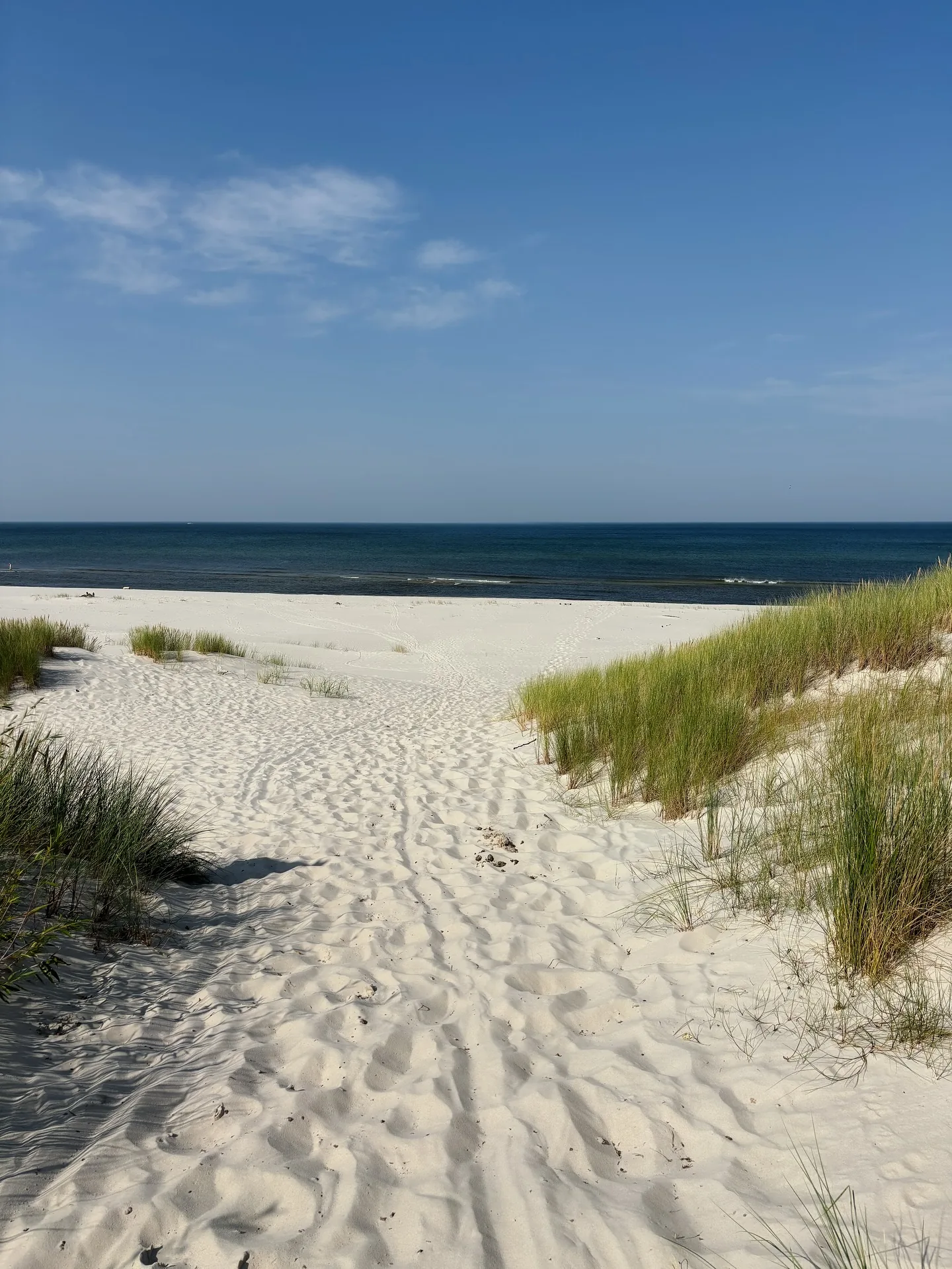 Zejście przez wydmy na szeroką, pustą plażę Bałtyku